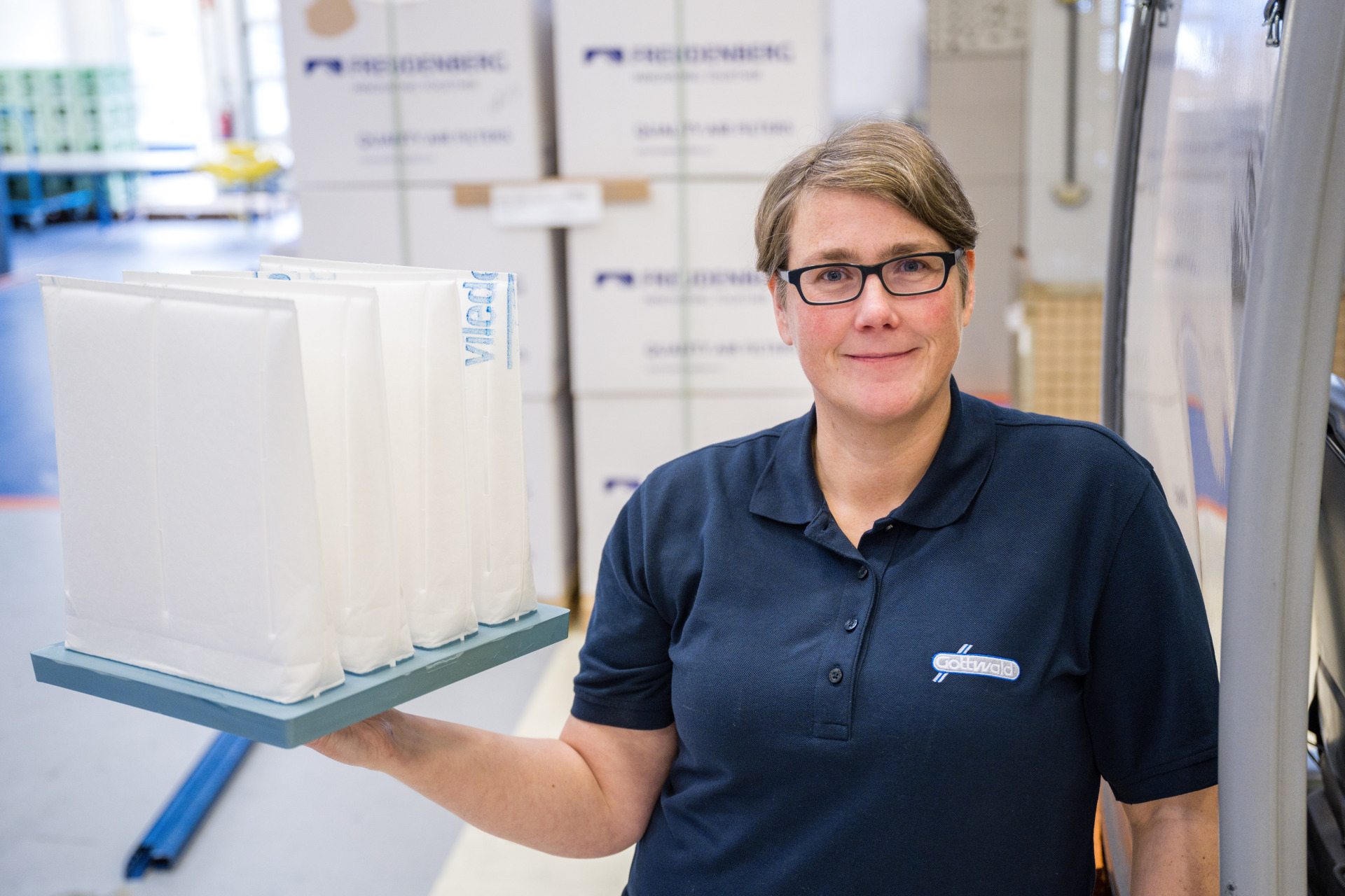 Mitarbeiterin von Gottwald hält einen Taschenfilter Luftfilter von Viledon in der Hand.