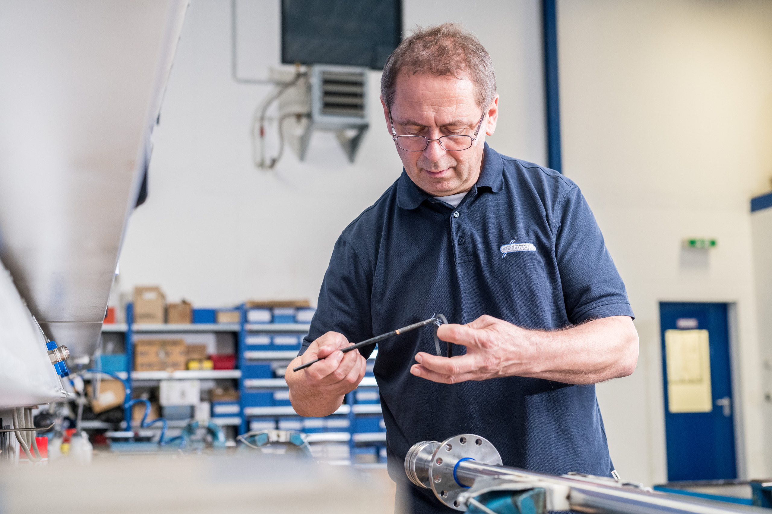 Mitarbeiter von Franz Gottwald arbeitet präzise an einem Maschinenteil in der Werkstatt.