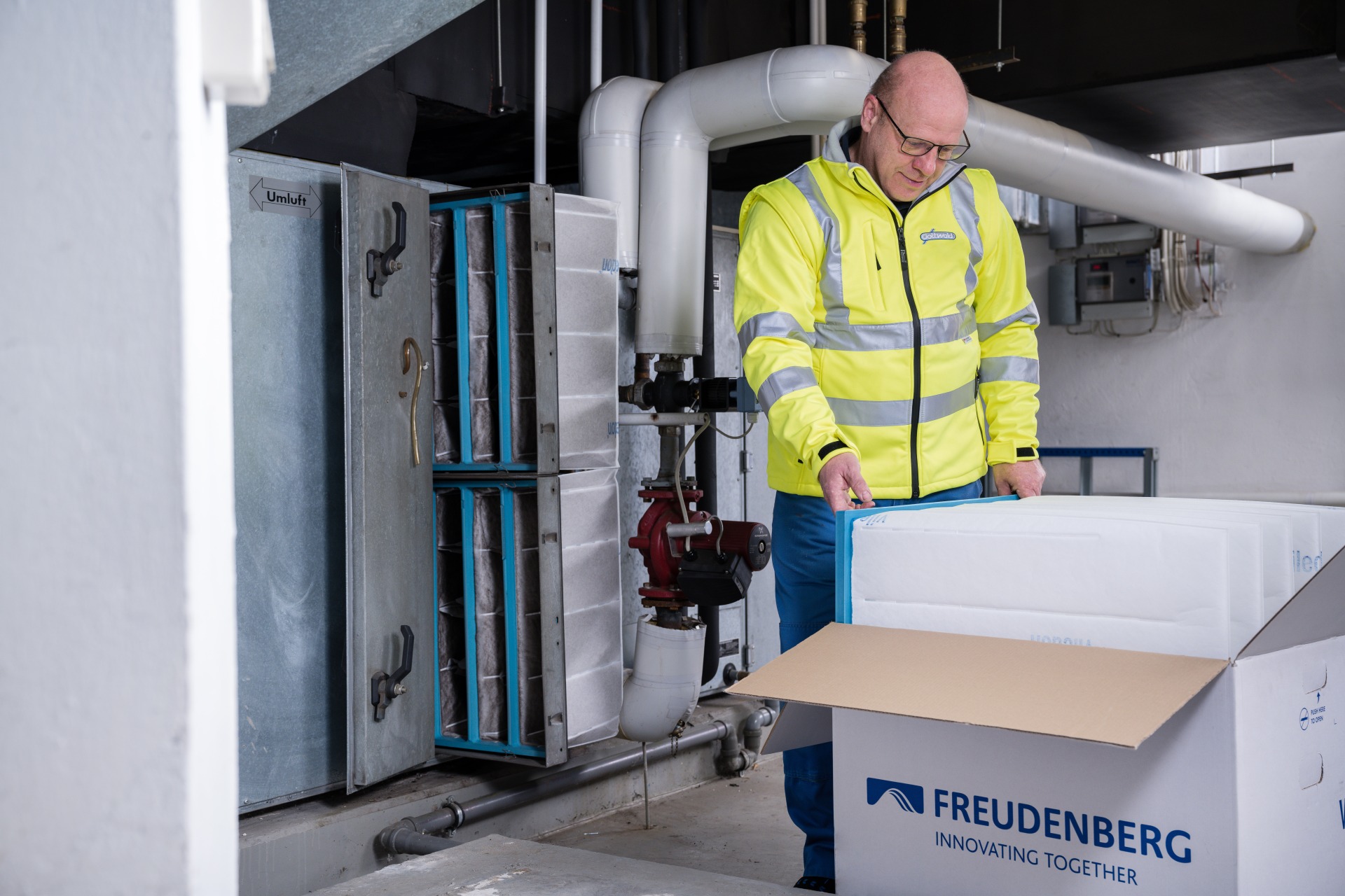 Ein Mitarbeiter der Franz Gottwald GmbH + Co. KG überprüft Viledon-Luftfilter von Freudenberg in einer Lüftungsanlage.