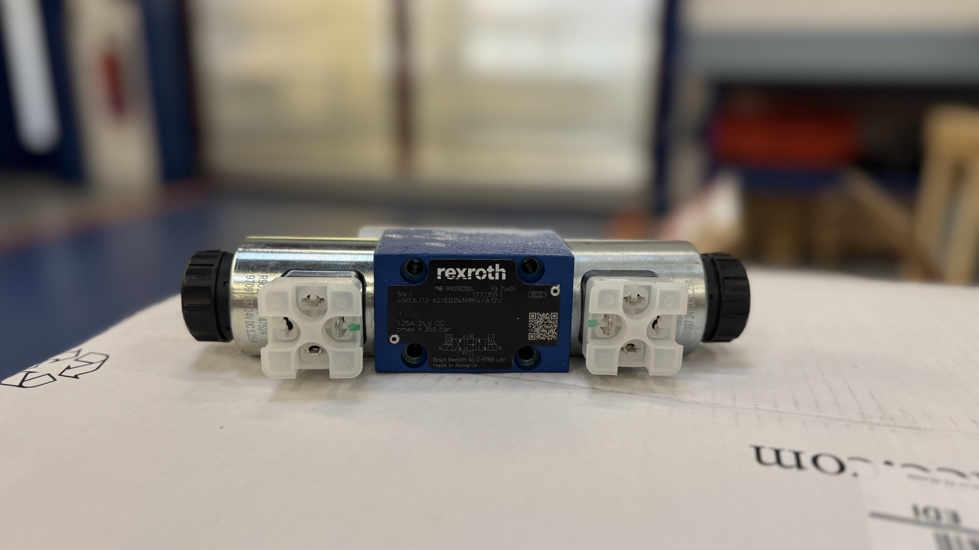 Ein Bosch Rexroth Hydraulikventil liegt auf einer Verpackung im Lagerbereich von Franz Gottwald.