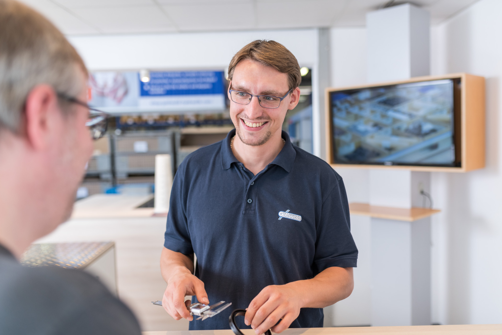 Mitarbeiter von Gottwald berät einen Kunden am Tresen.