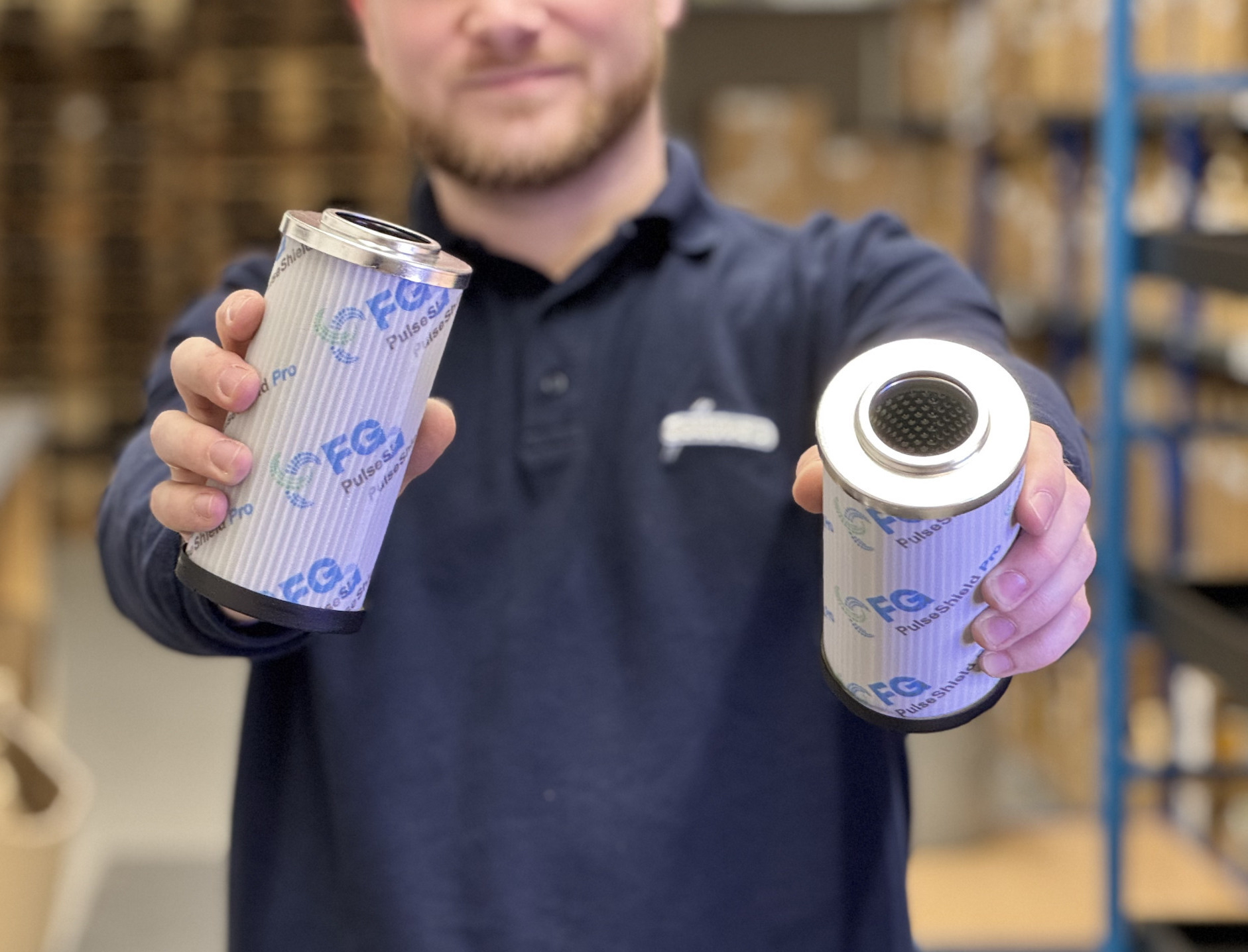 Mitarbeiter der Franz Gottwald GmbH + Co. KG zeigt zwei Hydraulikfilterelemente von Filtration Group.