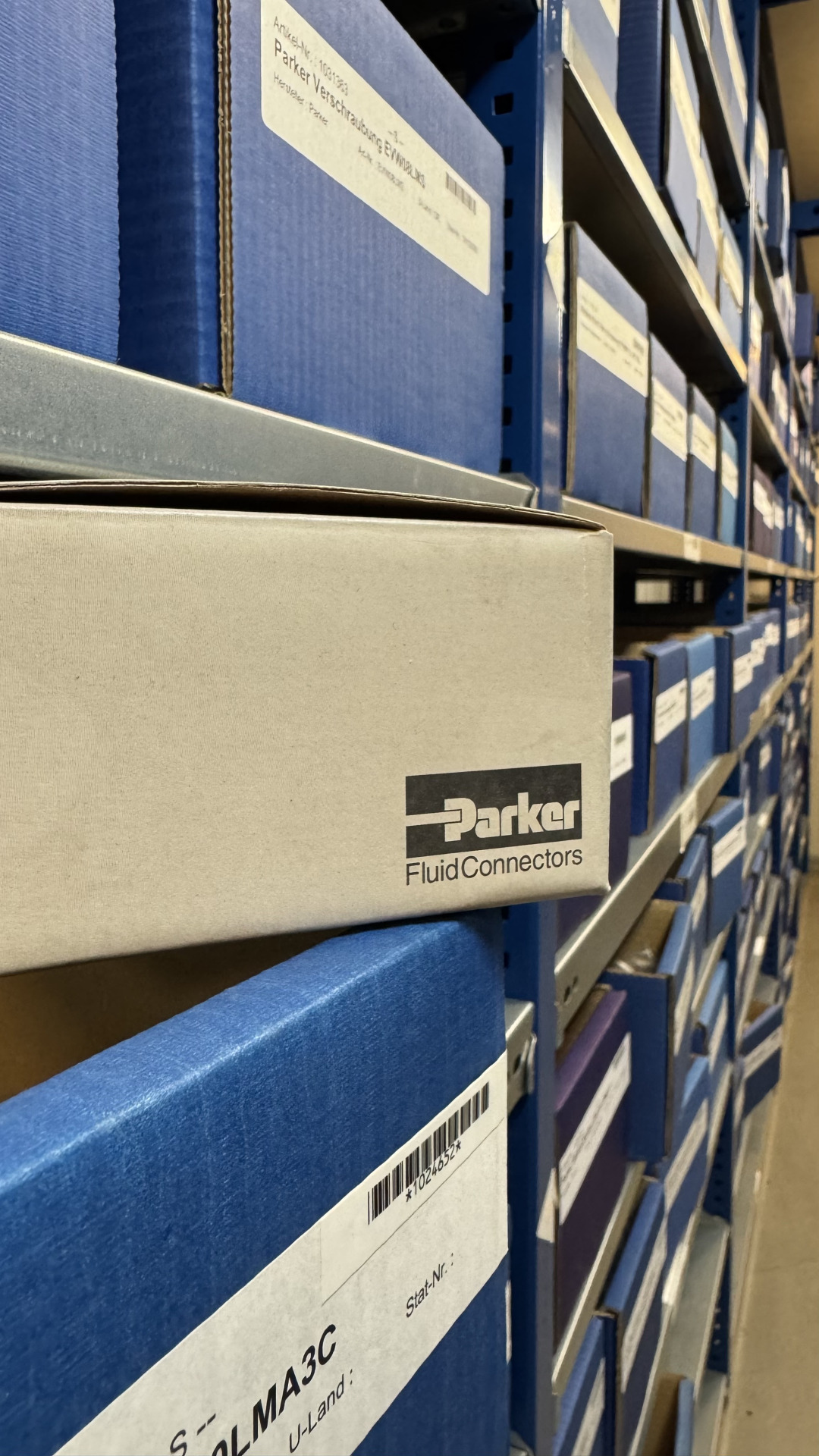 Lagerregal mit Parker-Verschraubungen in blauen Kartons bei der Franz Gottwald GmbH + Co. KG.