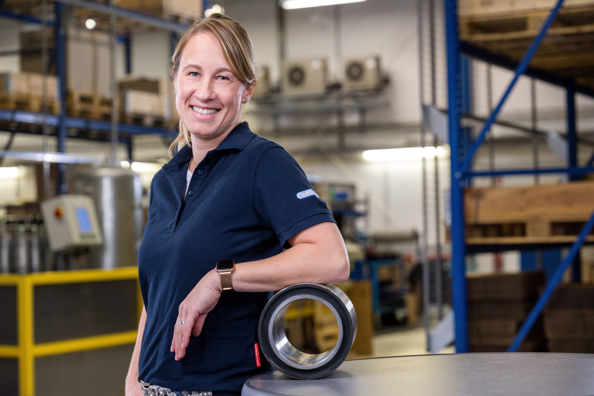 Eine Mitarbeiterin von Franz Gottwald lehnt lächelnd an einem Tisch mit einer Ultrabuchse.