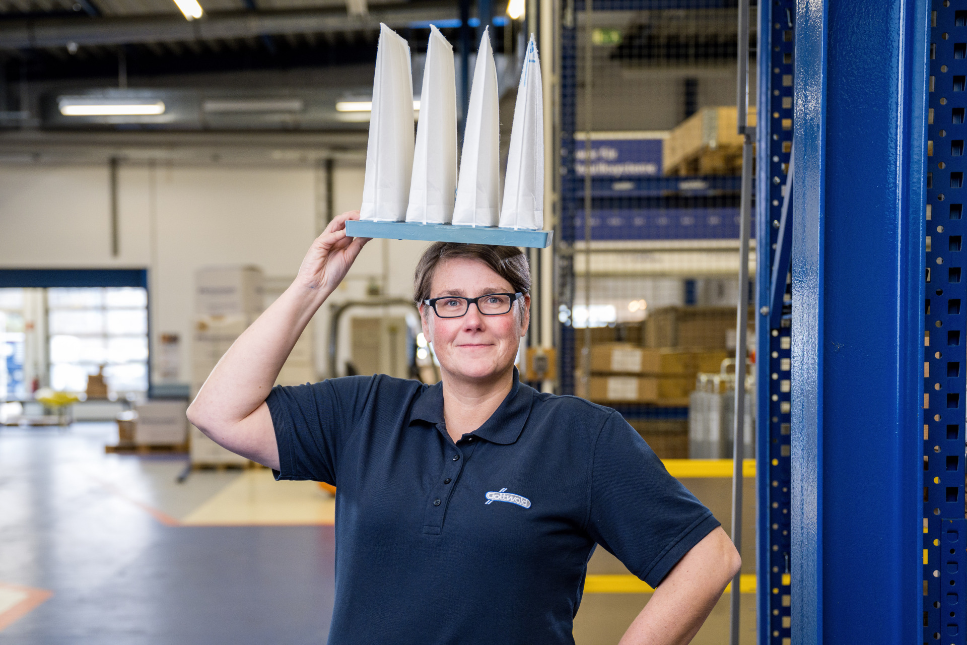 Eine Mitarbeiterin von Gottwald schaut freundlich in die Kamera mit einem Taschenfilter auf dem Kopf.