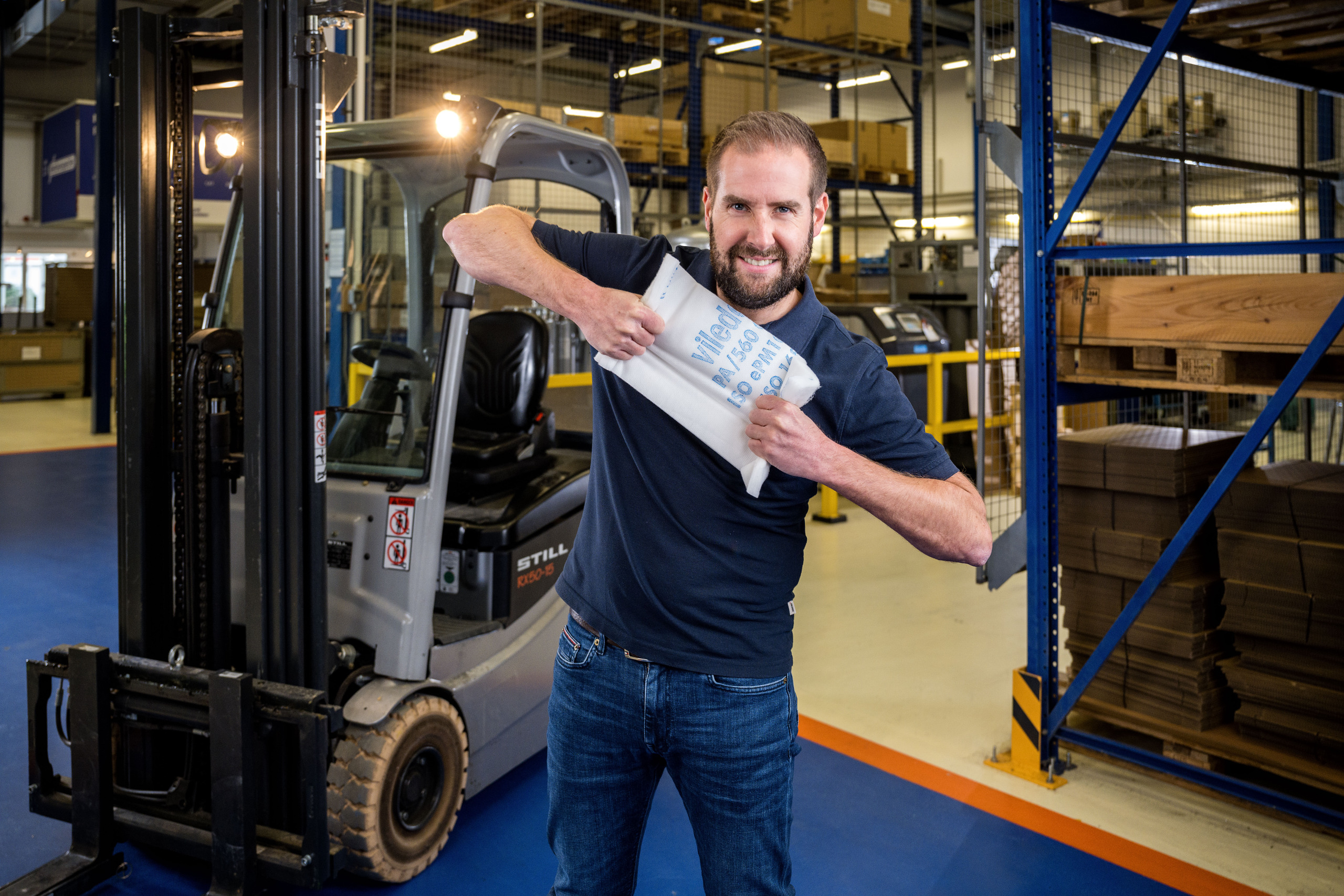 Mitarbeiter von Franz Gottwald mit einem Luftfilterzuschnitt in der Logistikhalle.