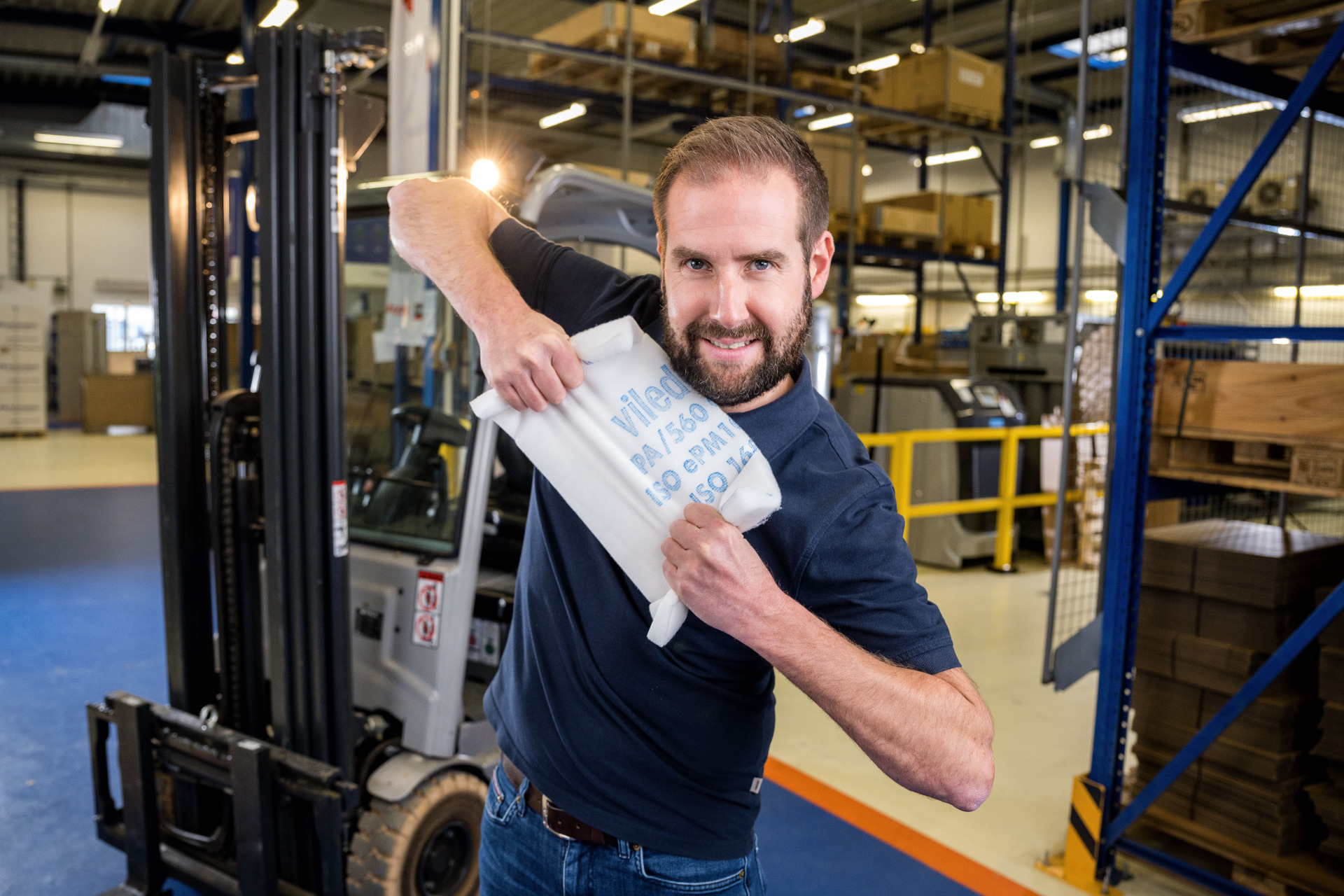 Mitarbeiter von Franz Gottwald zeigt einen Filterzuschnitt von Viledon in der Logistikhalle.