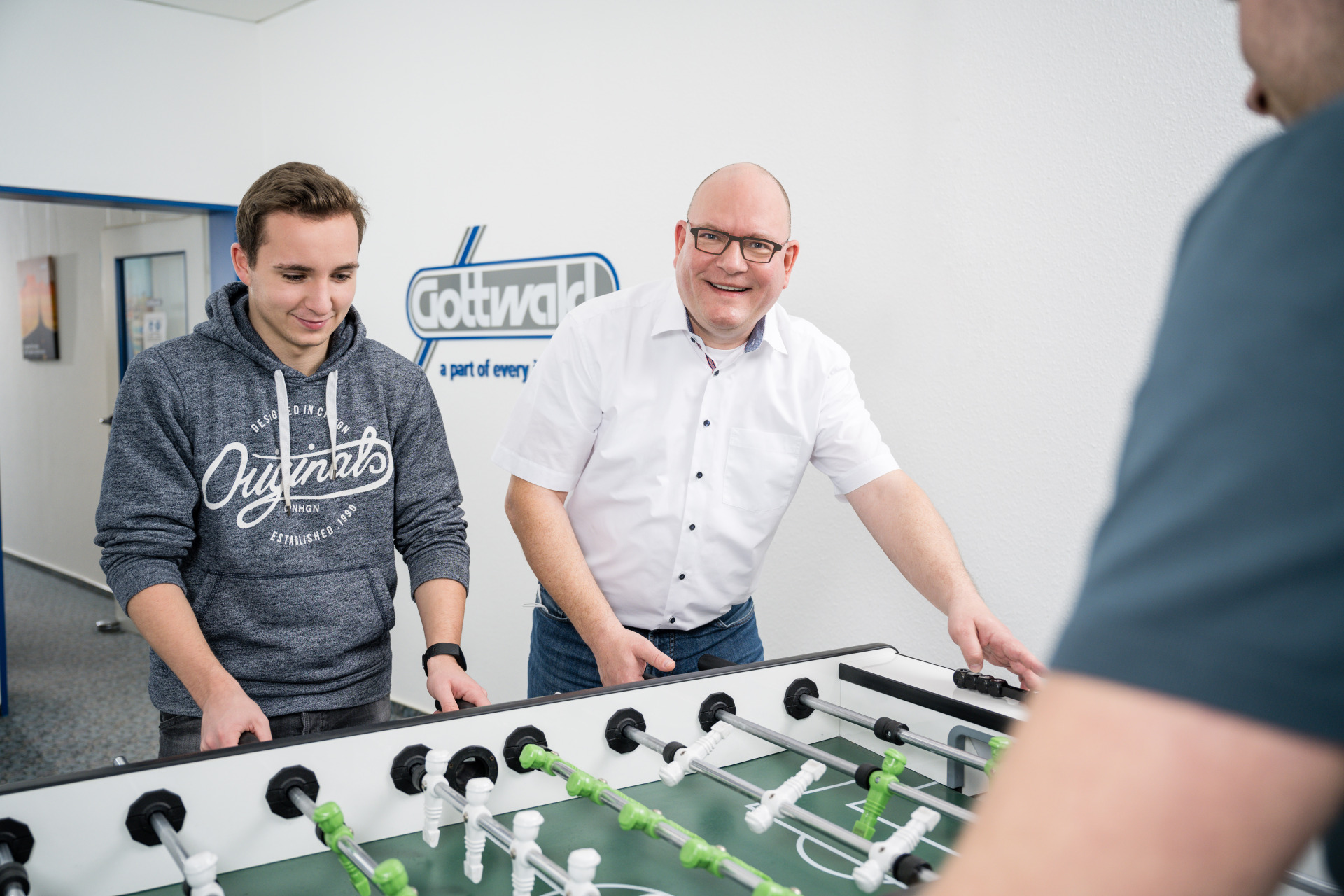 Ein Auszubildender von Gottwald spielt mit dem Chef am Kickertisch