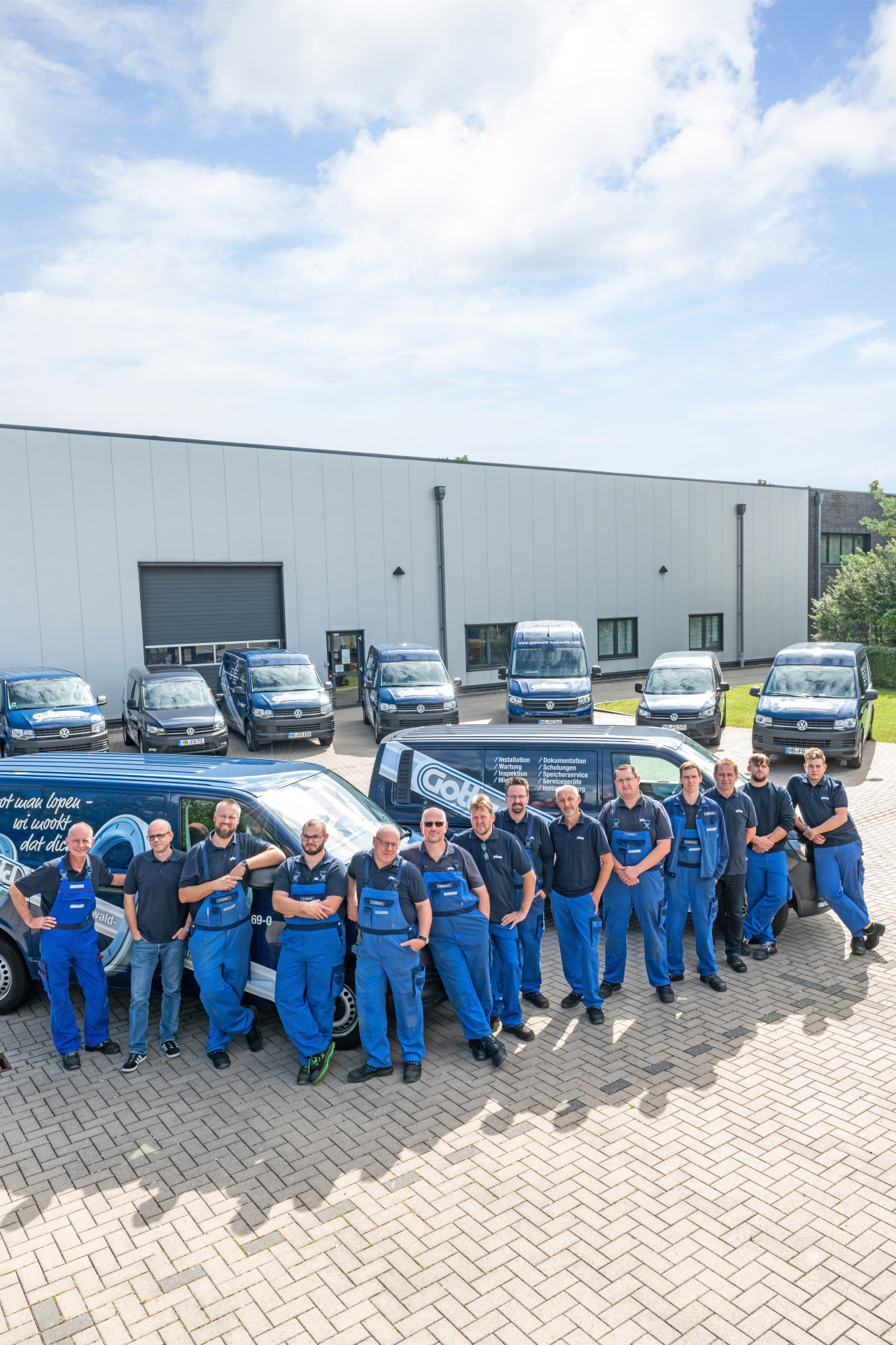Das Serviceteam von Franz Gottwald steht in Arbeitskleidung vor den Firmenfahrzeugen auf dem Betriebsgelände.