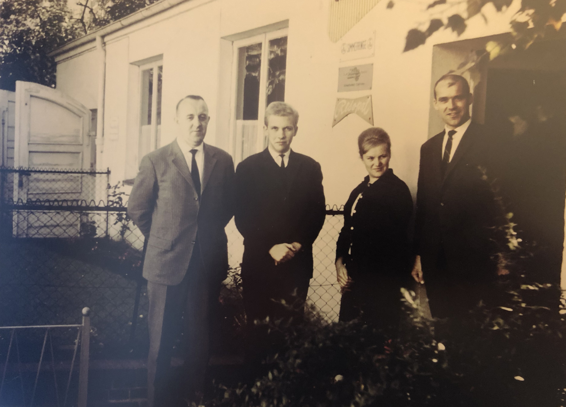 Herr Gottwald und Freunde stehen vor dem Eingang vom Büro.