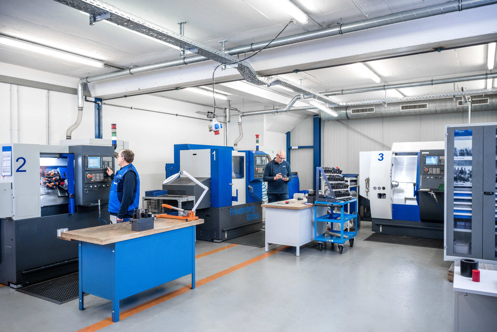 Einblick in die Fertigung bei Franz Gottwald: Zwei Mitarbeitende bedienen moderne CNC-Drehmaschinen.
