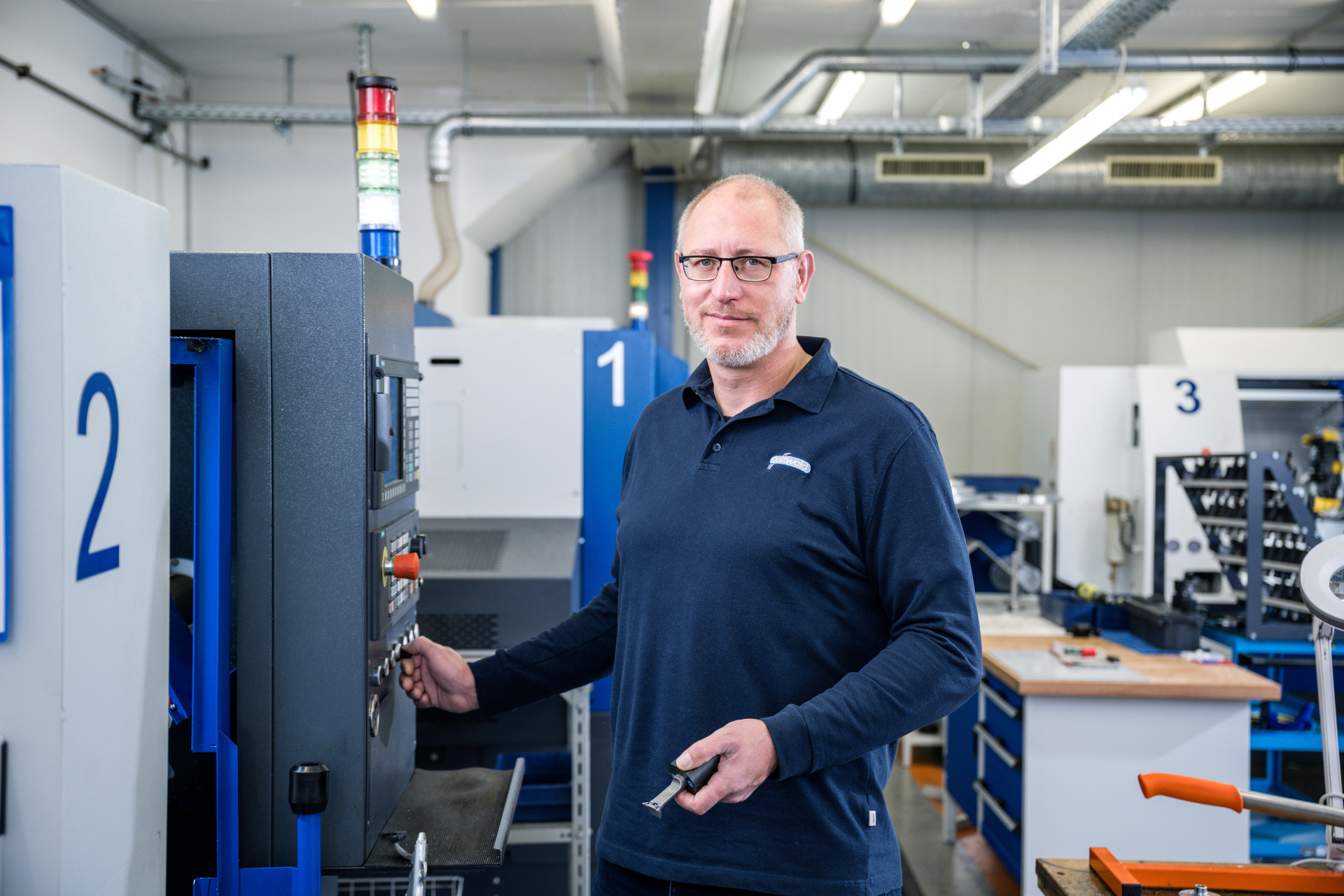 Mitarbeiter von Franz Gottwald bedient eine CNC-Maschine in der Fertigung