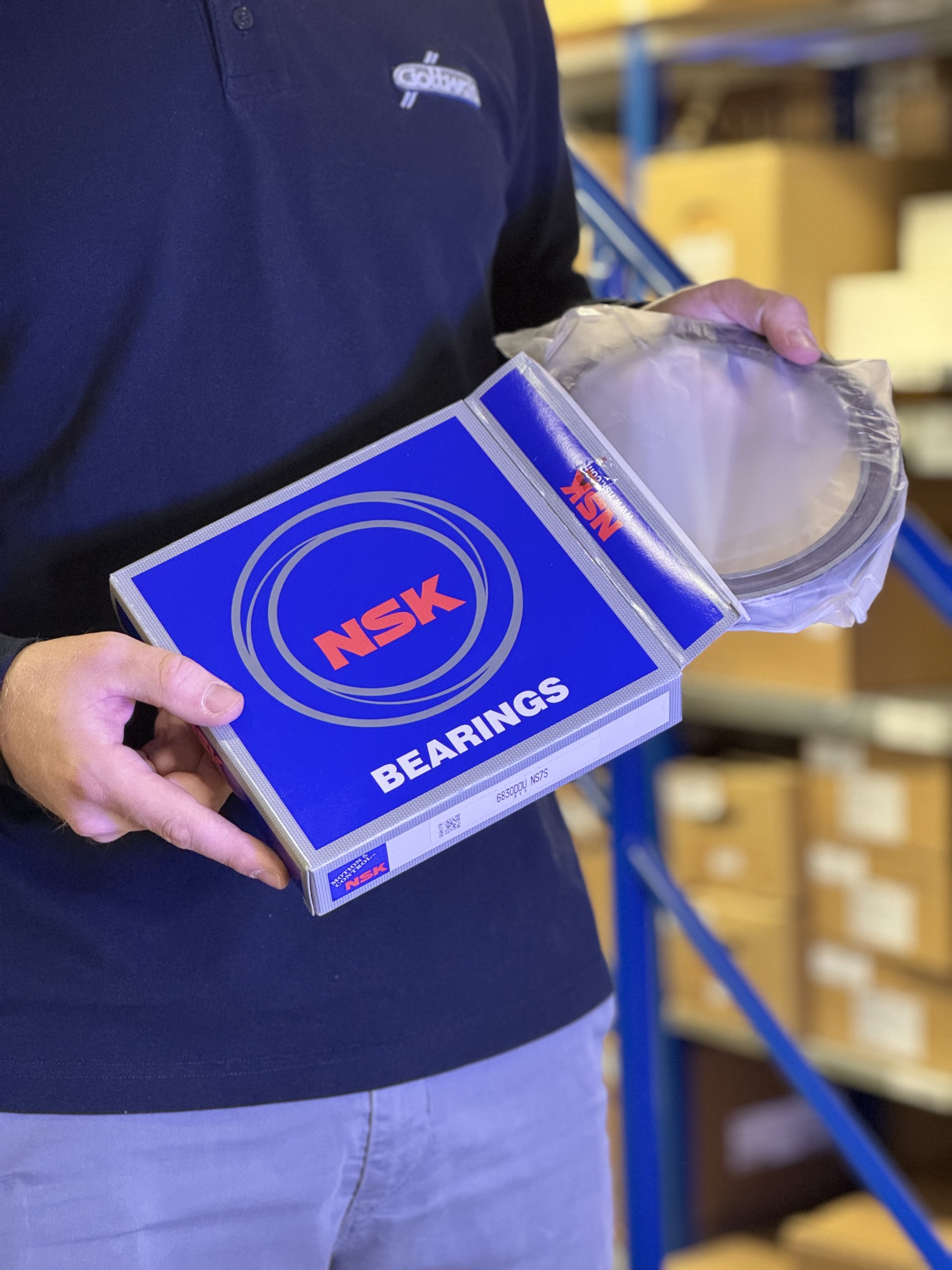 Mitarbeiter von Franz Gottwald hält ein NSK Lager mit Verpackung im Lager