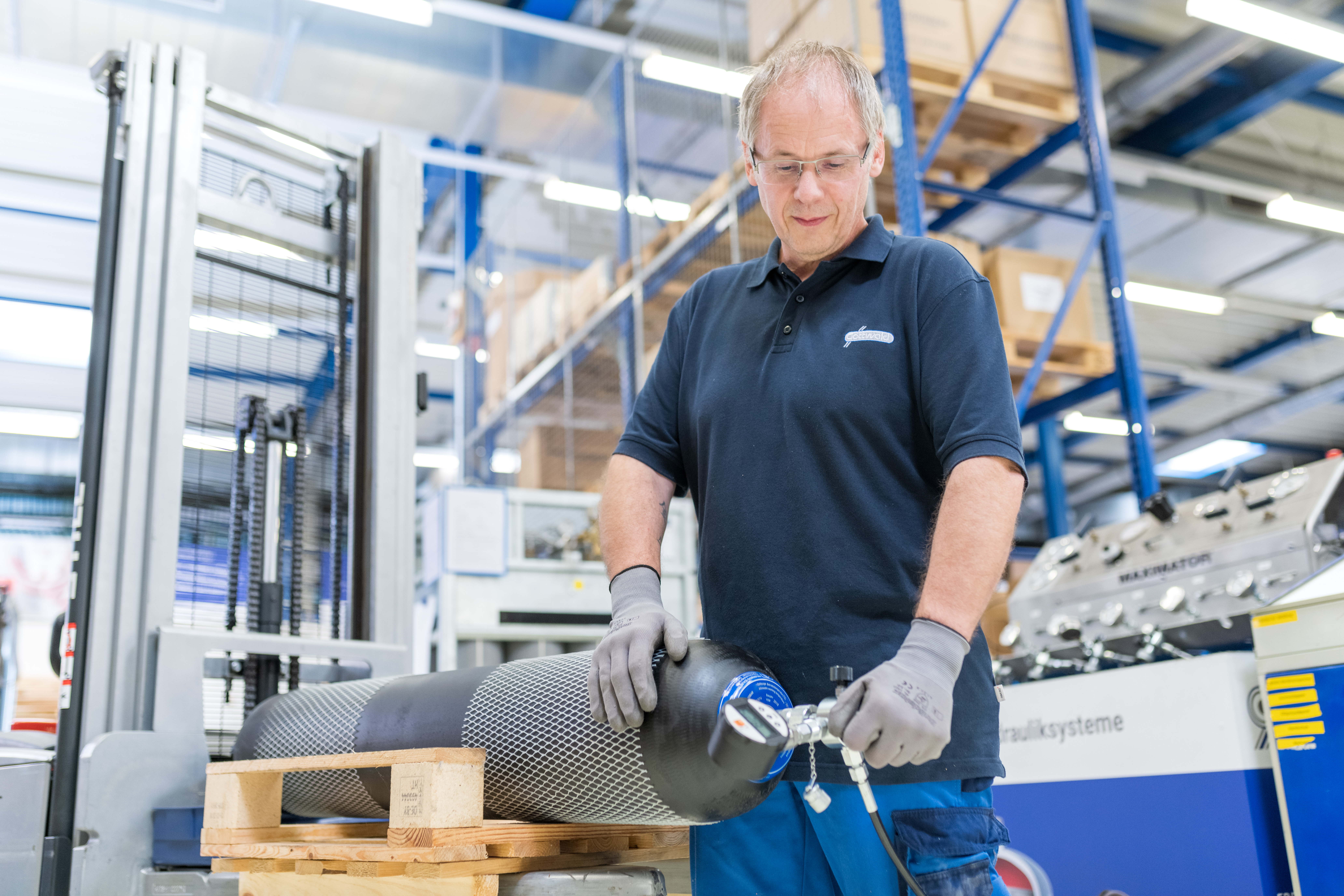 Mitarbeiter von Franz Gottwald prüft den Gasvordruck eines Hydrospeichers in der Werkstatt